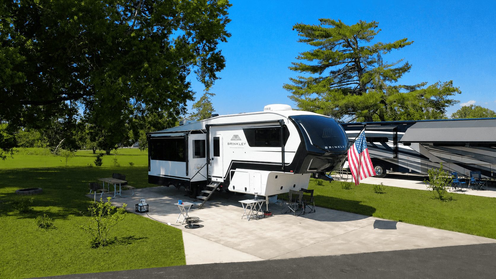 Full-hookup RV site with a fifth-wheel and American flag at Carolina Camp Cedar near Clemson